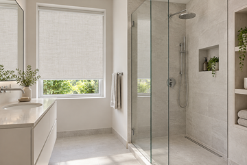 Small bathroom renovation with glass shower and ivory roller shade