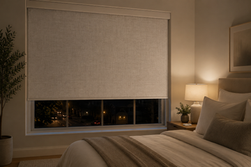 Motorized blackout roller shades covering a street-facing bedroom window
